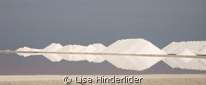 Reflections. Salt piles behind the drying ponds. Bonaire by Lisa Hinderlider 